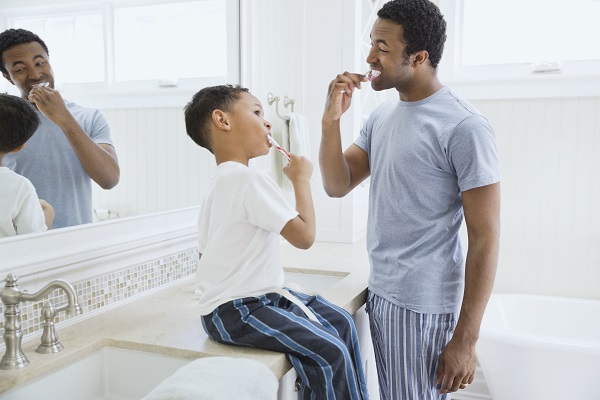 father and son brushing teeth in the morning