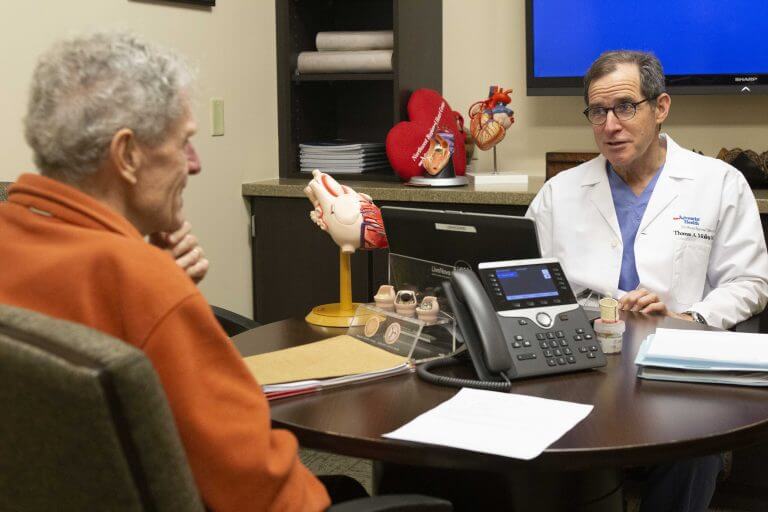 Doctor sitting across desk from elderly patient