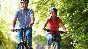 two peopel riding bikes in woods